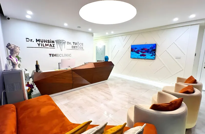 Reception desk with orange sofas and armchairs in the waiting lounge